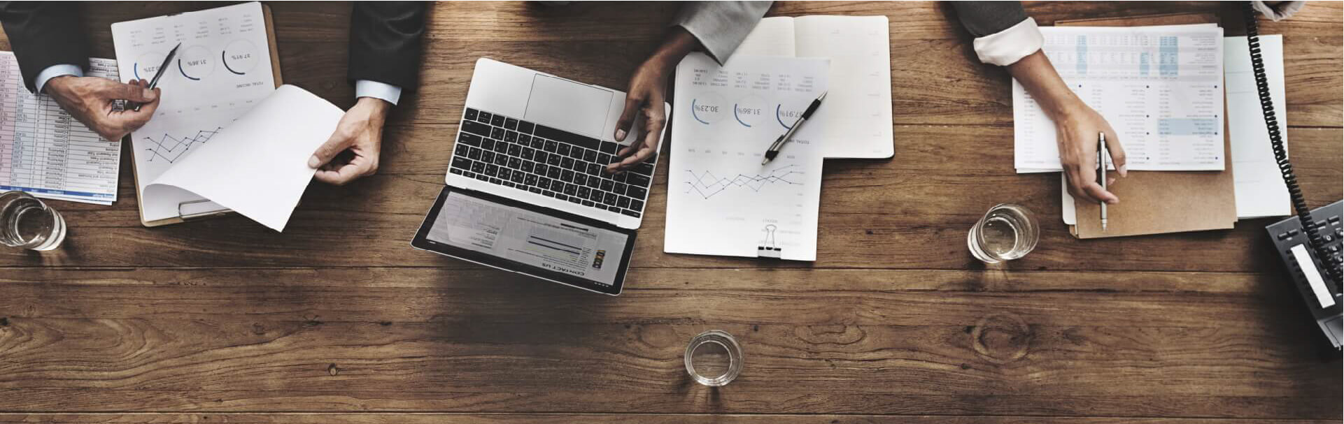 Business people looking papers and computers on a desk